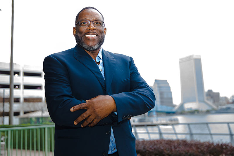 black male patient smiling outside of the dental office