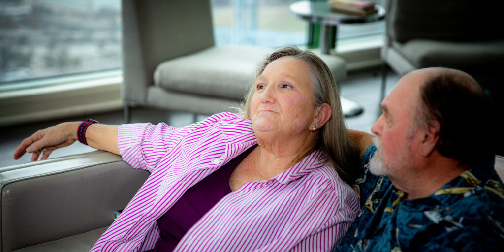 female patient sitting on the couch within the dental office with their partner