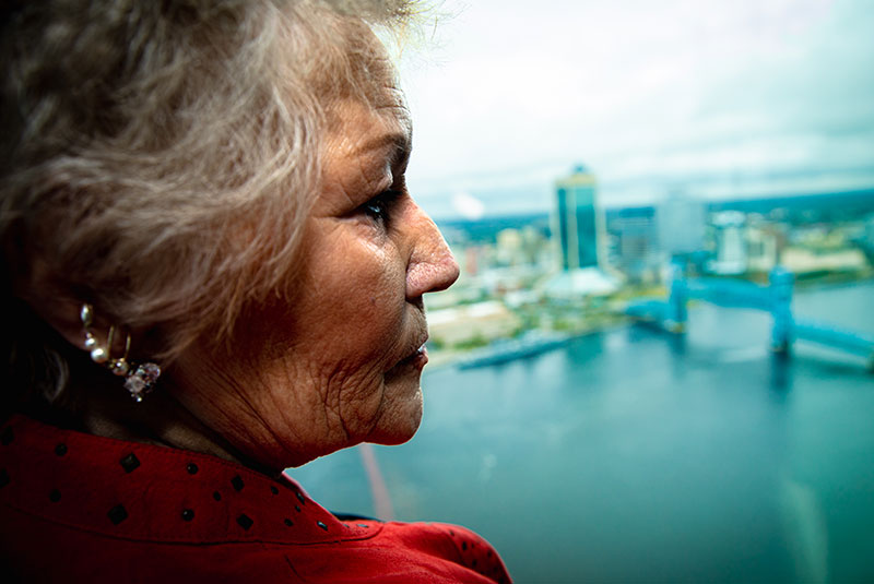 Older female patient looking out into the bay within the dental office