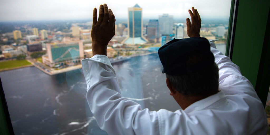 older male patient looking outside into the bay from the dental office